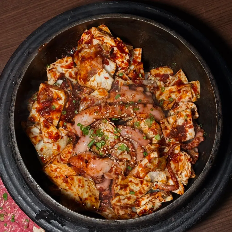Steam rising from the straw-fire cauldron knife-cut octopus