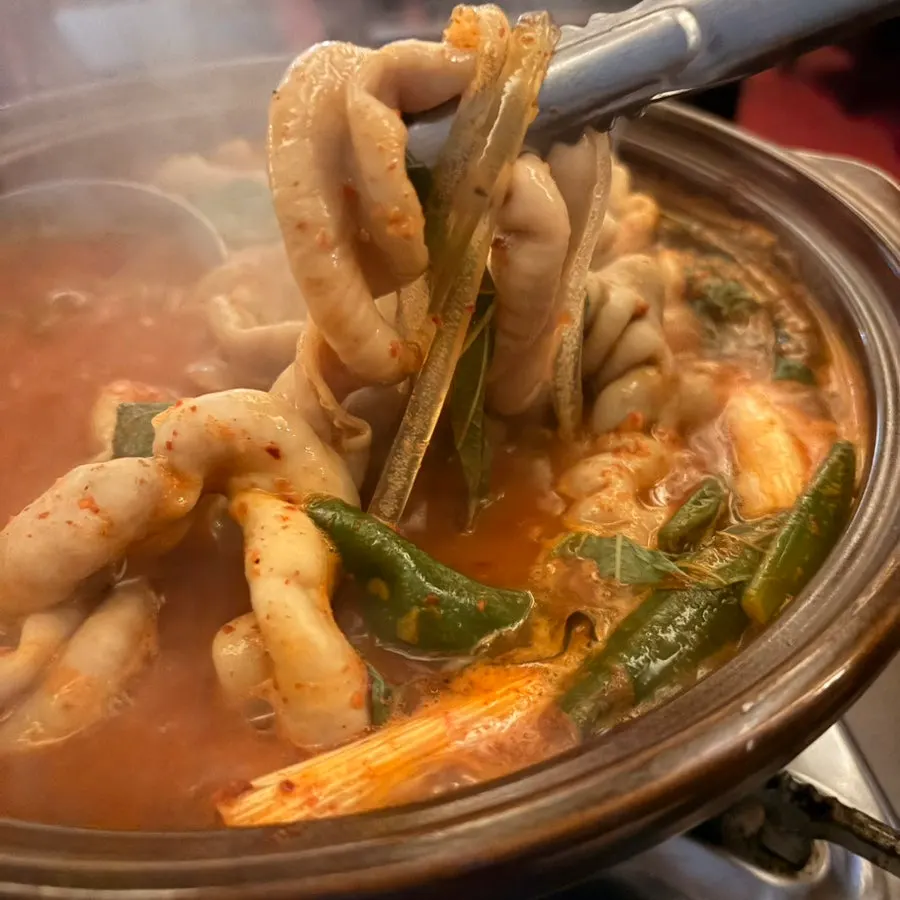 A bowl of gopchang stew with sharp, spicy broth