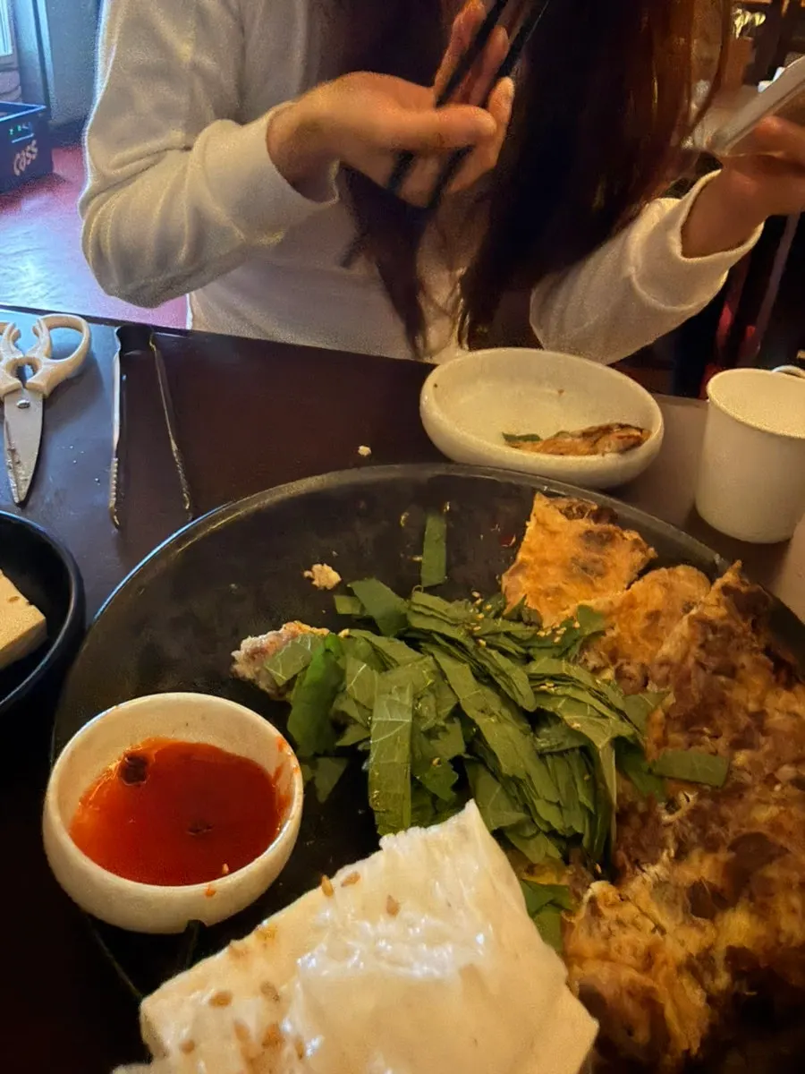 A bite of yuk-jeon topped with tofu and kimchi