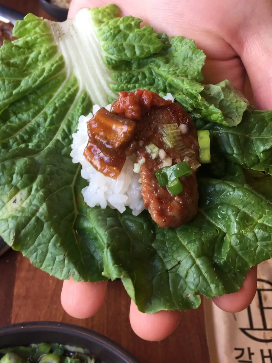 쌈채소에 밥과 갈비, 표고와사비를 올린 한 쌈