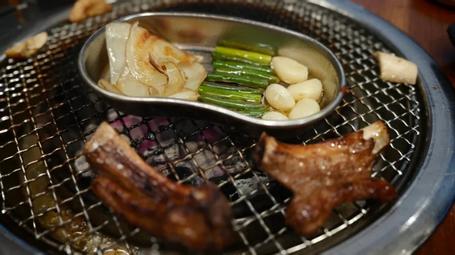 Grilled potatoes with garlic stems and garlic in a bowl