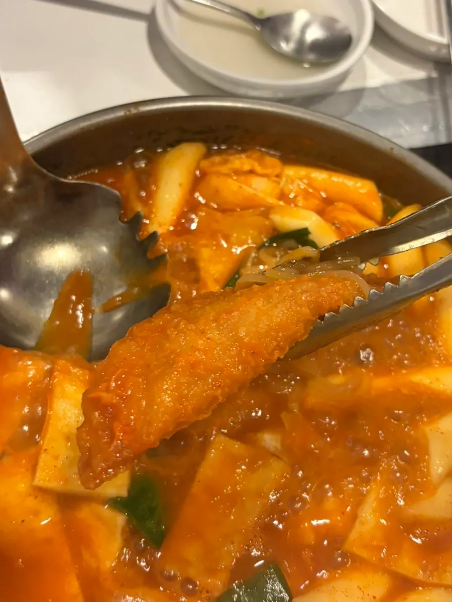Broth-soaked jjolmyeon noodles lifted out of the pot