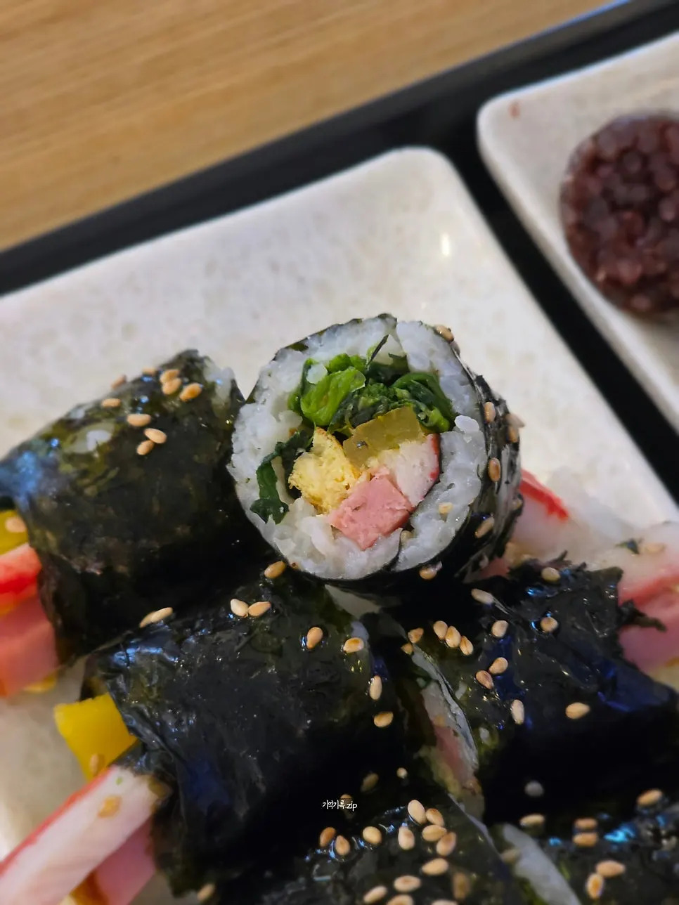 Cross-section of mini gimbap filled with seasoned vegetables