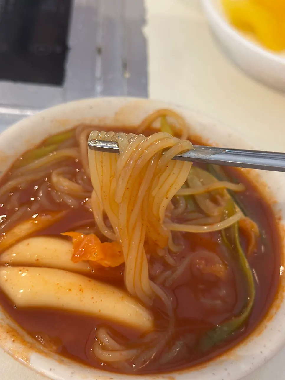 Chopsticks lifting up jjolmyeon noodles