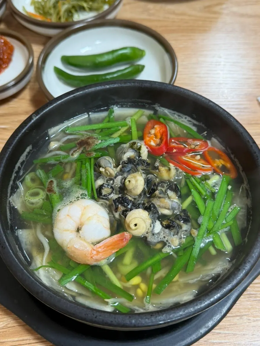 Two ttukbaegi pots, sea snail haejangguk and spicy abalone soondubu