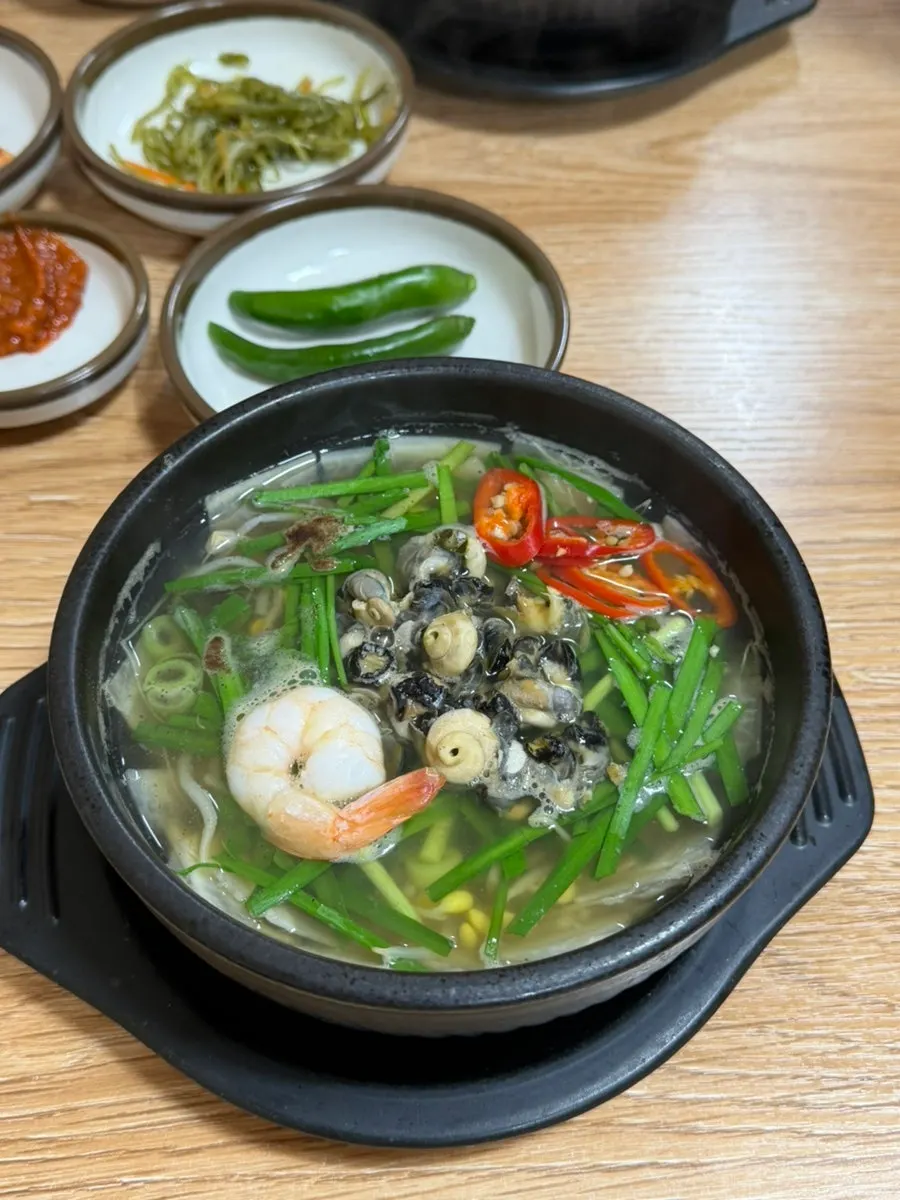 Sea snail haejangguk topped with chives and bean sprouts