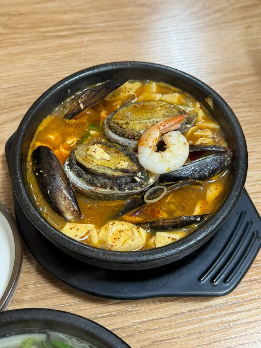 Two whole abalones in their shells with mussels and whole shrimp