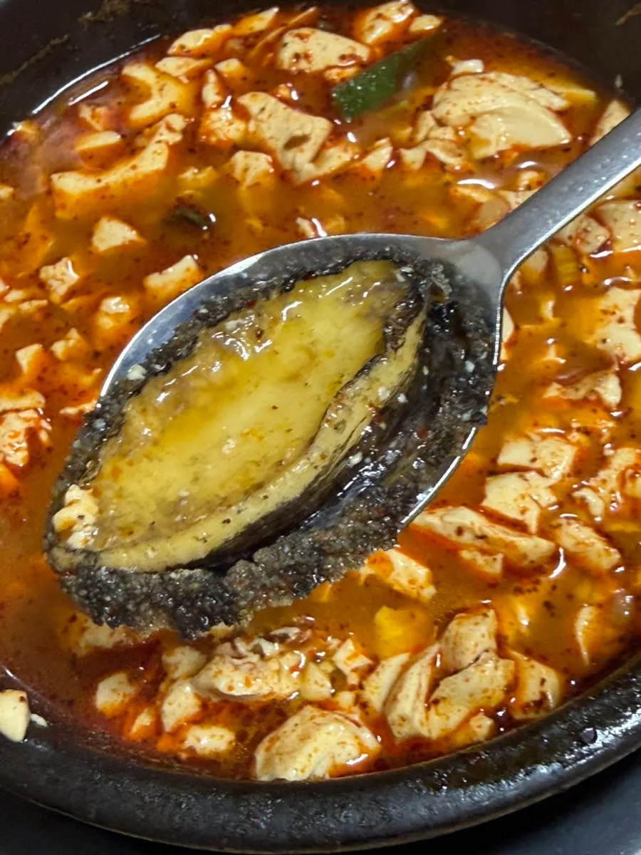 Whole shrimp and mussels inside the abalone soondubu