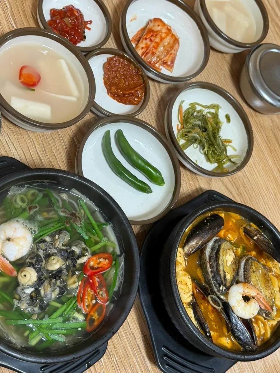 Table set with both the sea snail haejangguk and abalone soondubu pots