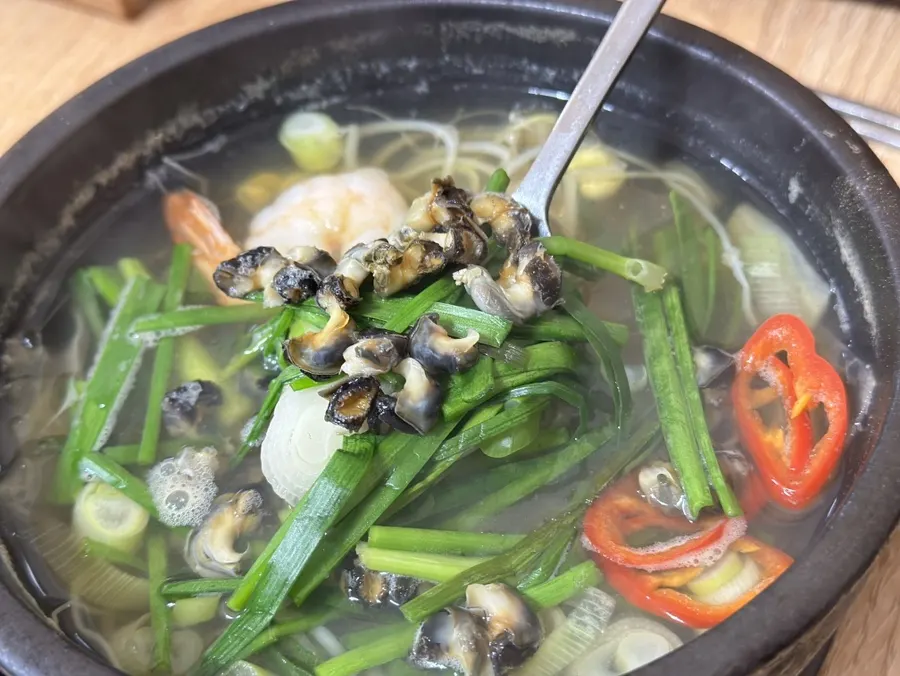 A spoonful of top shells lifted from the soup