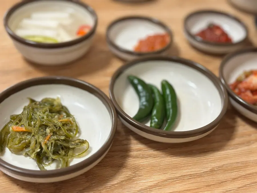 A spoonful of naejangtang with rice and kimchi on top