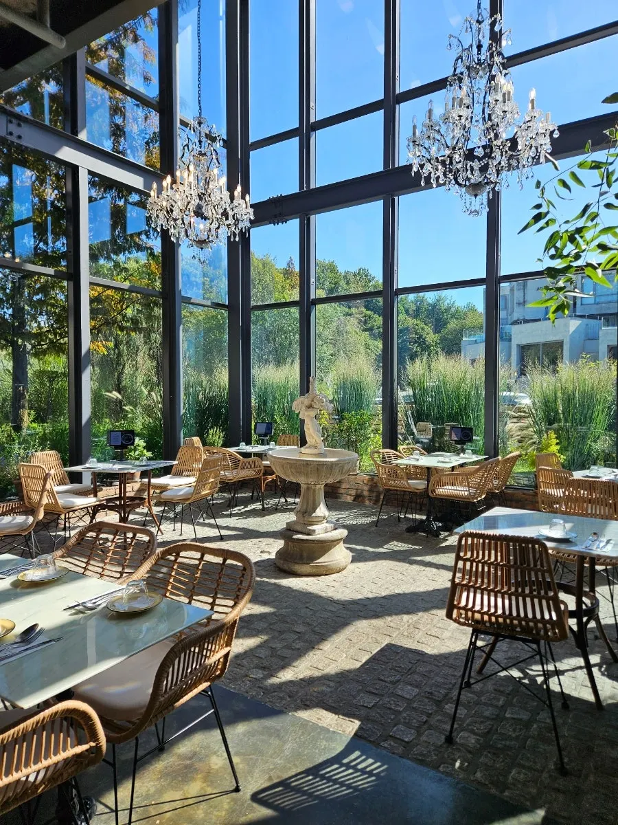 Ground-floor greenhouse space with floor-to-ceiling windows and a chandelier