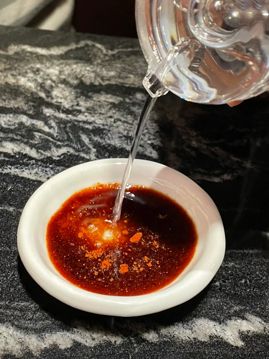 Cross-section of sweet and sour pork dipped in sauce