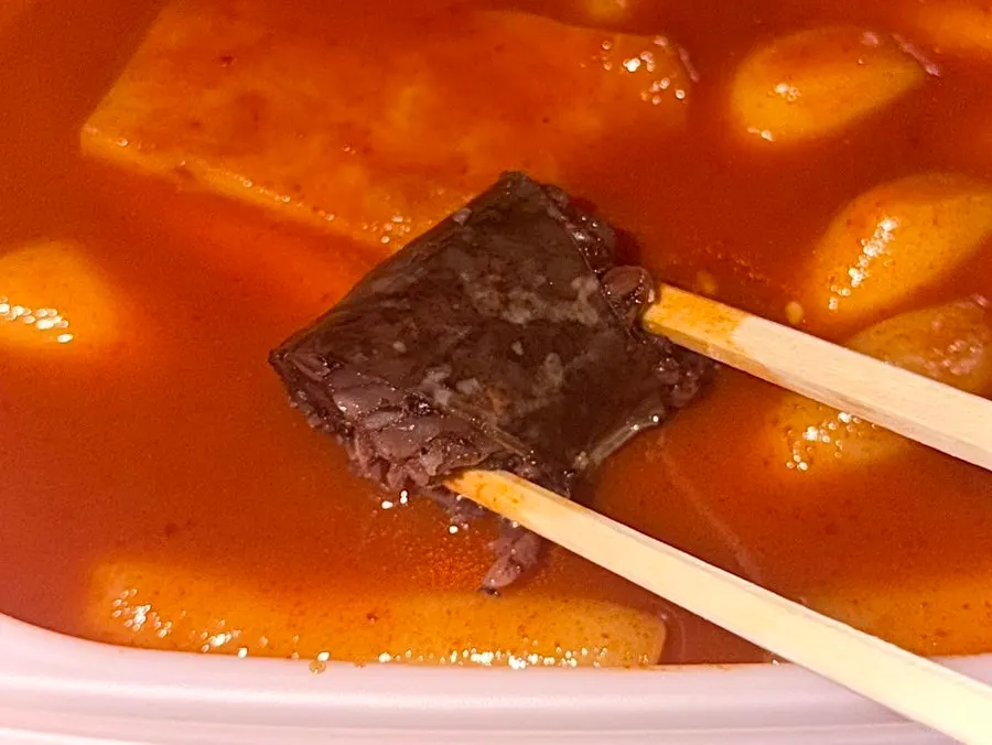 Sundae dipped into tteokbokki sauce