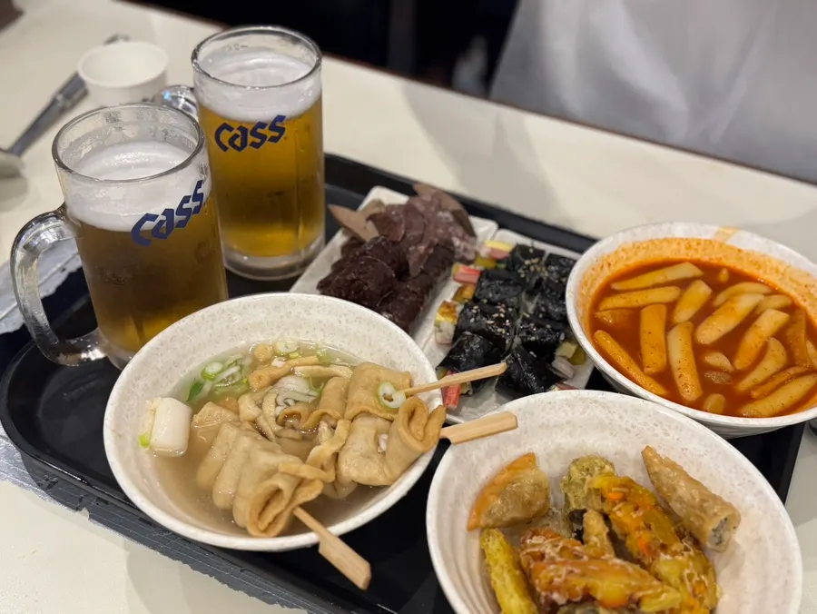Two glasses of draft beer served alongside the tteokbokki