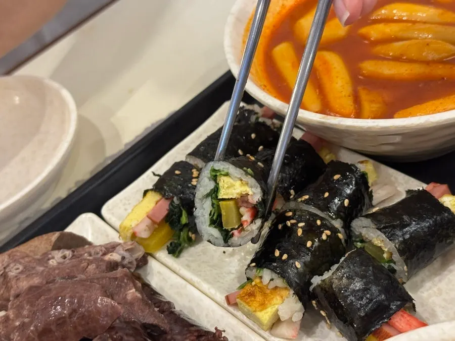 Dipping a fritter into the tteokbokki sauce