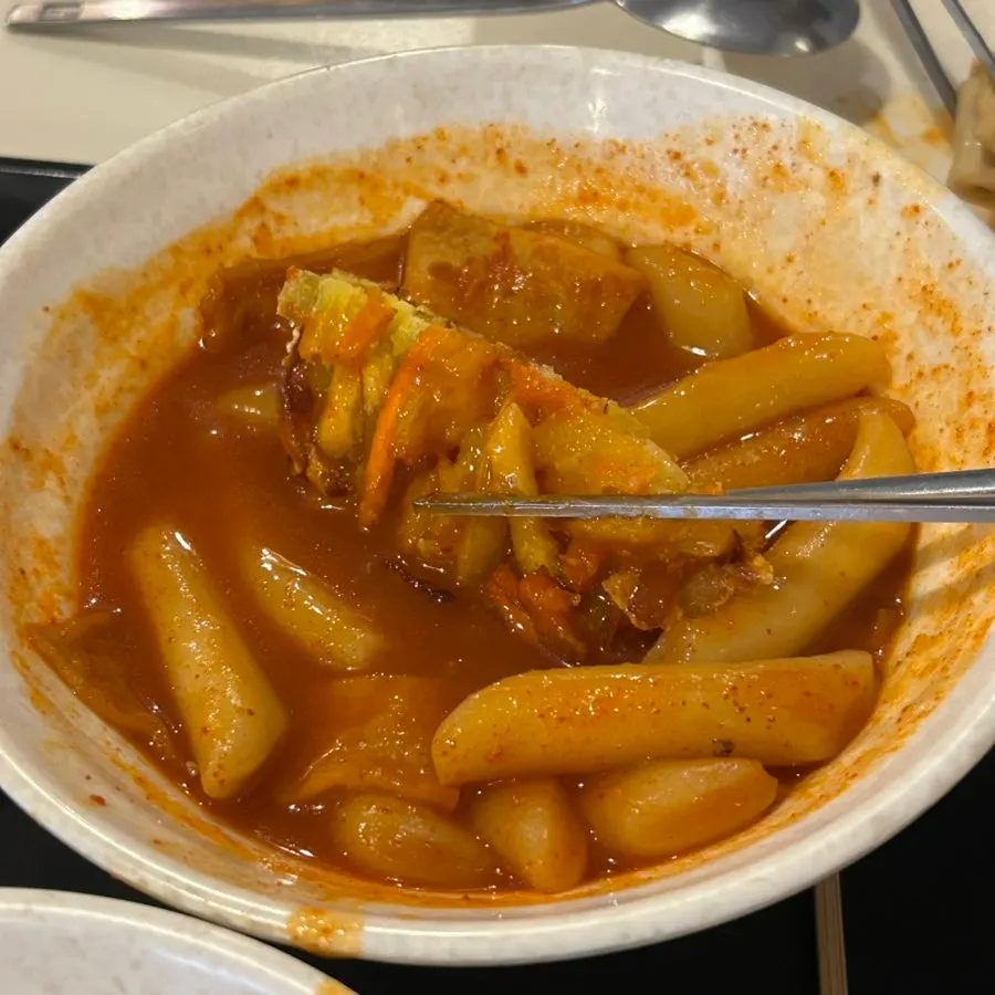 Assorted fritters dipped in tteokbokki sauce