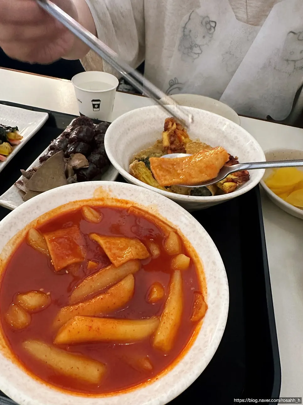 Lifting a piece of rice cake from the tteokbokki