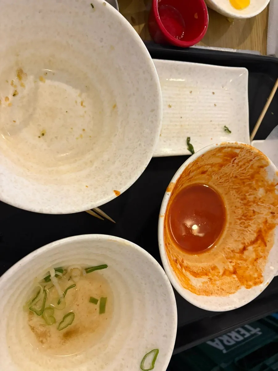 Empty tteokbokki bowl and a glass of draft beer