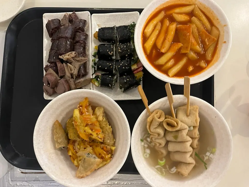 A spread of tteokbokki, fritters, and sundae