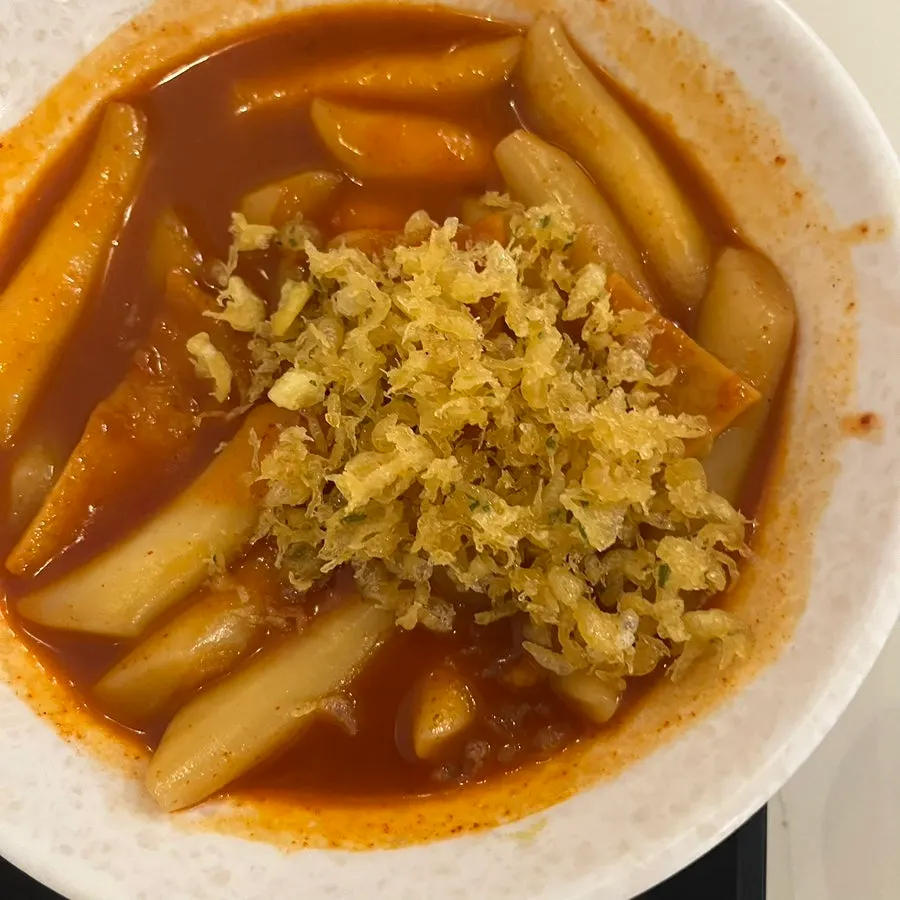 Scooping up tteokbokki sauce with a spoon