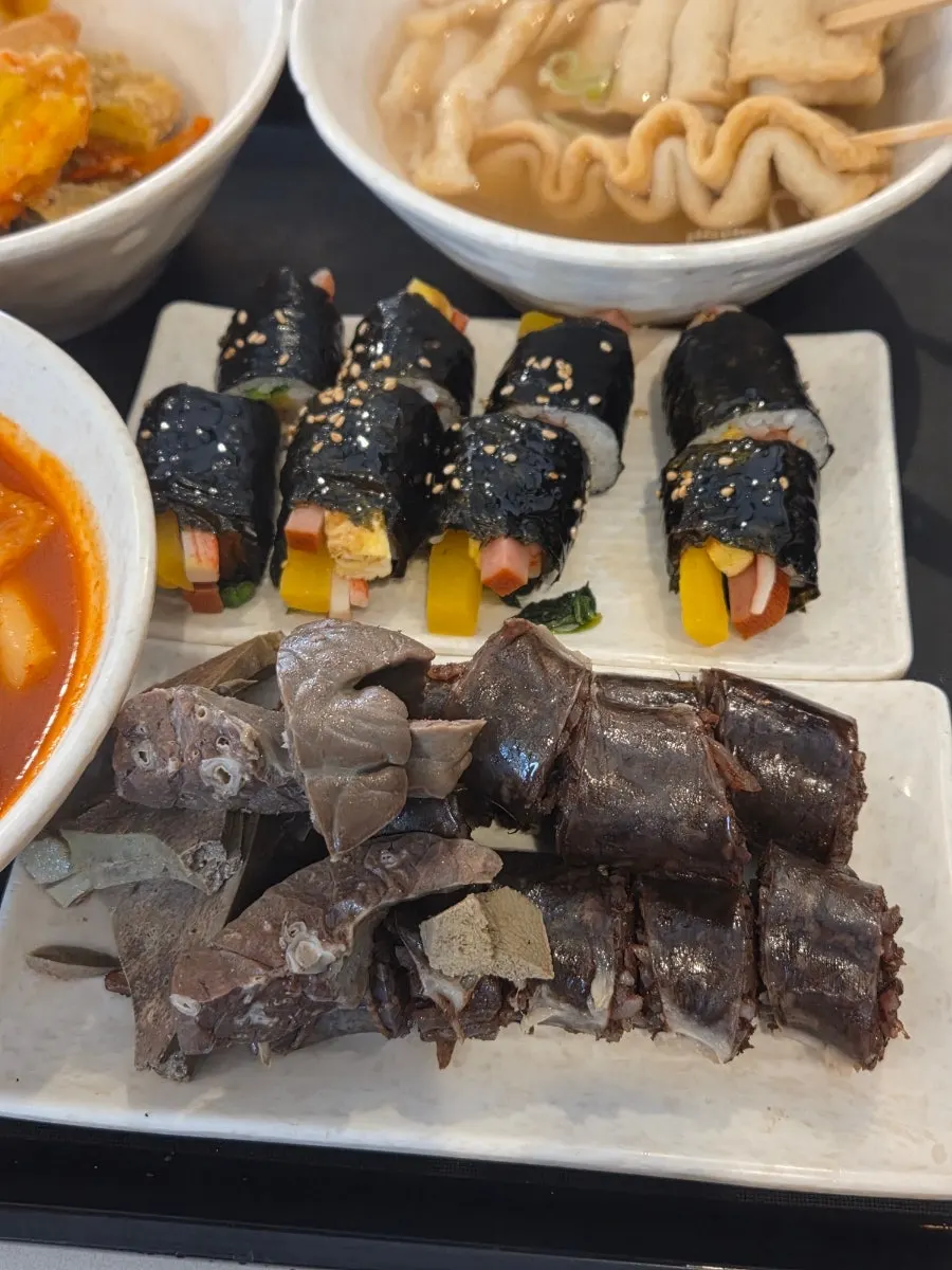 Mini gimbap dipped in tteokbokki sauce