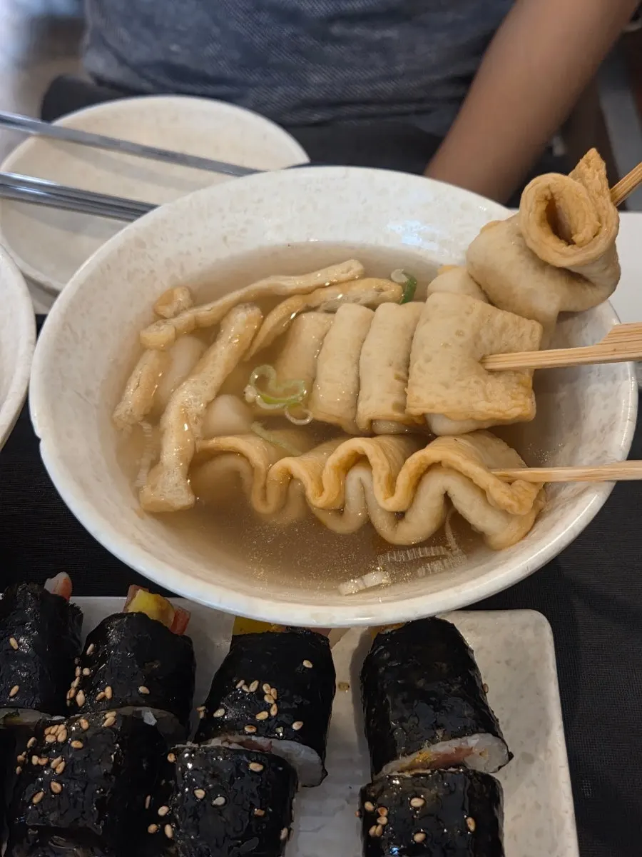 A fritter dipped into tteokbokki broth