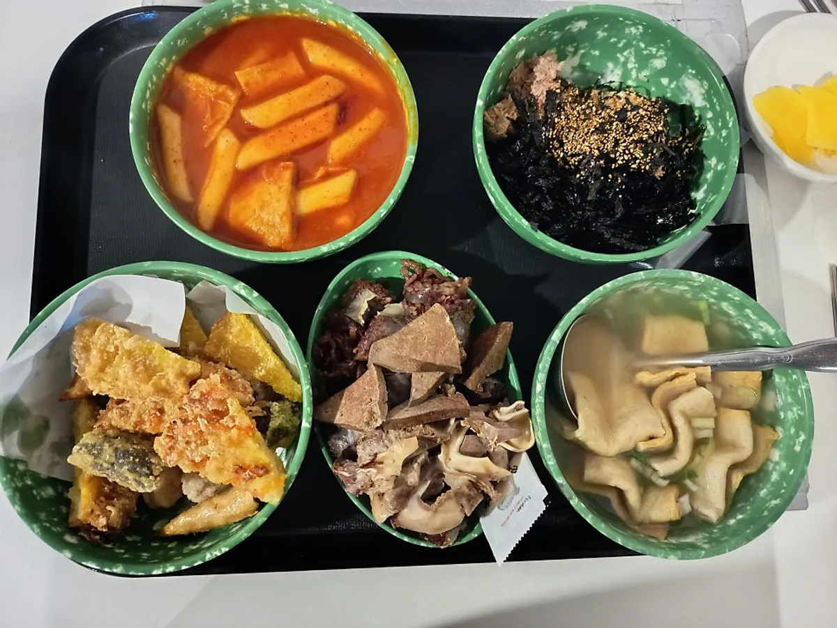 The Hyeonseon combo with tteokbokki, sundae, and fried snacks served together