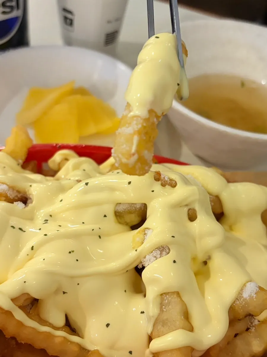 Close-up of fries drizzled with butter garlic sauce