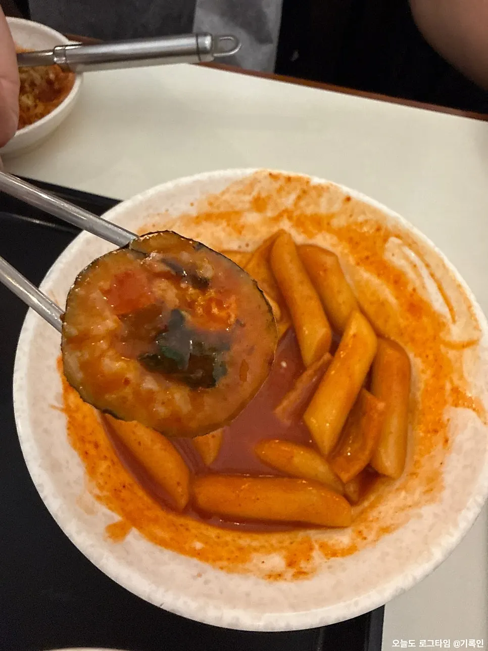 Mini gimbap dipped in tteokbokki sauce