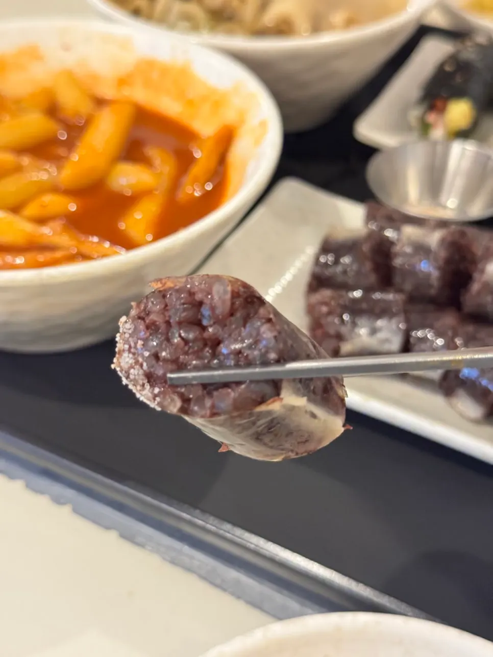 Sundae and tteokbokki plated together on a small plate