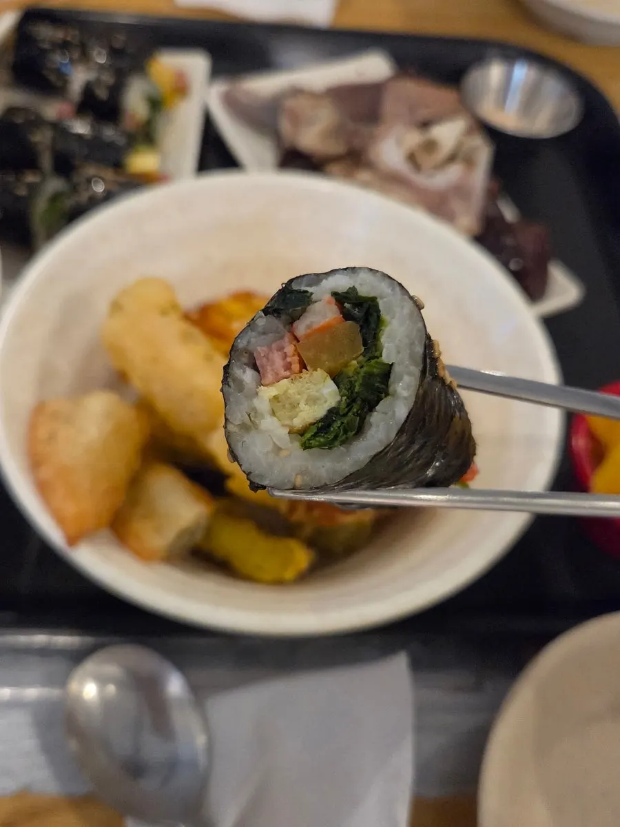 Mini gimbap dipped in tteokbokki broth