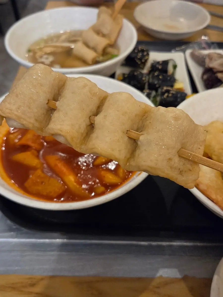 Full snack-food spread alongside fish cake broth