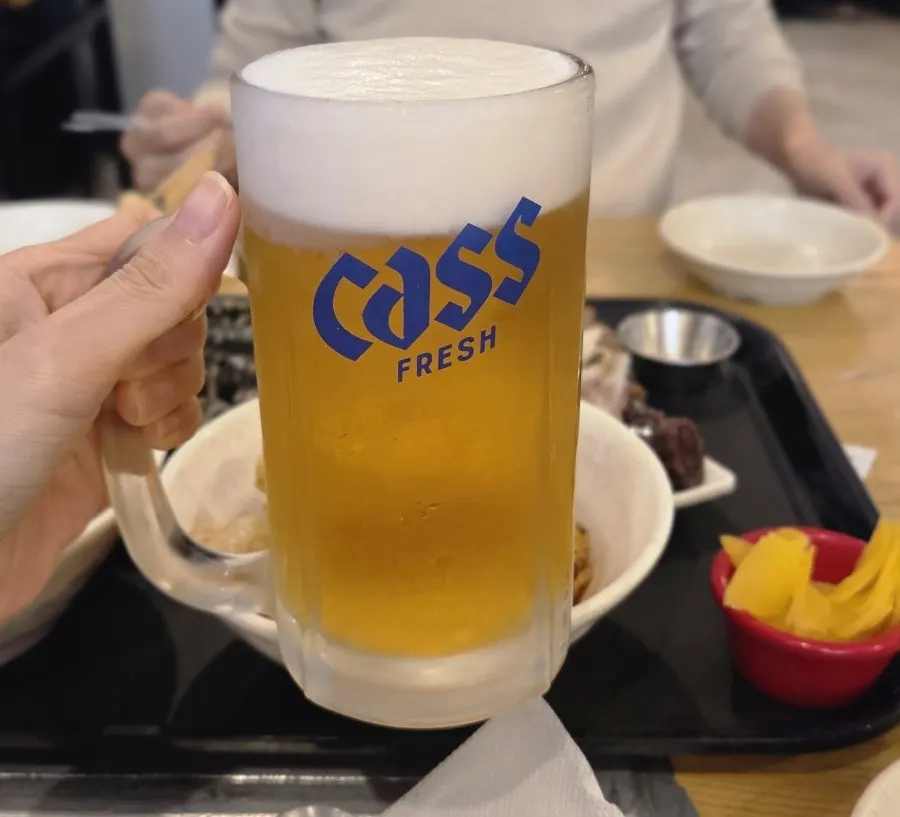 A glass of draft beer served with tteokbokki