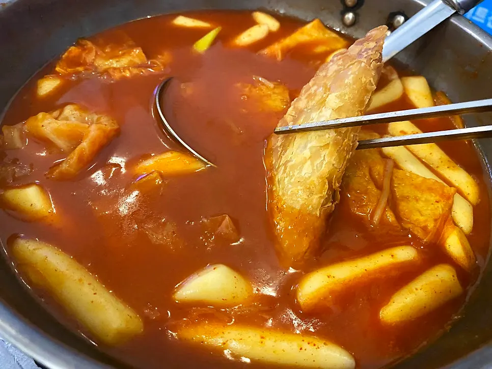 Yakimandu dipped into the reduced tteokbokki broth
