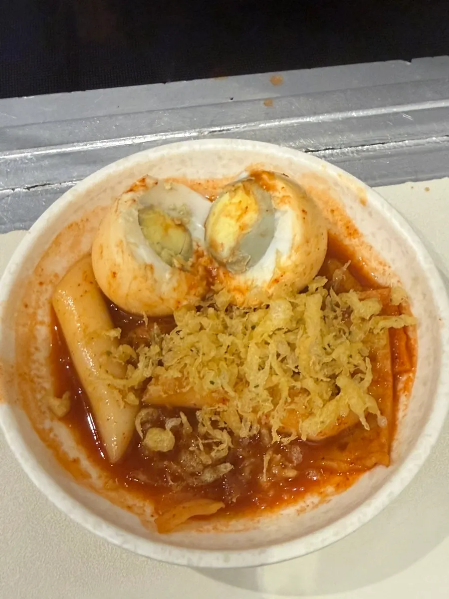 Instant tteokbokki topped with fried batter flakes