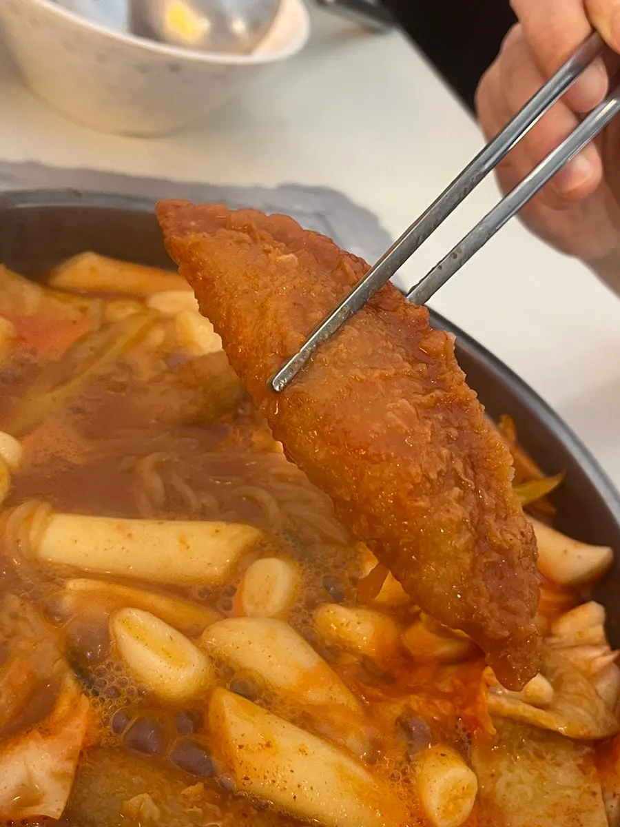 Fried batter bits piled on top of the tteokbokki broth