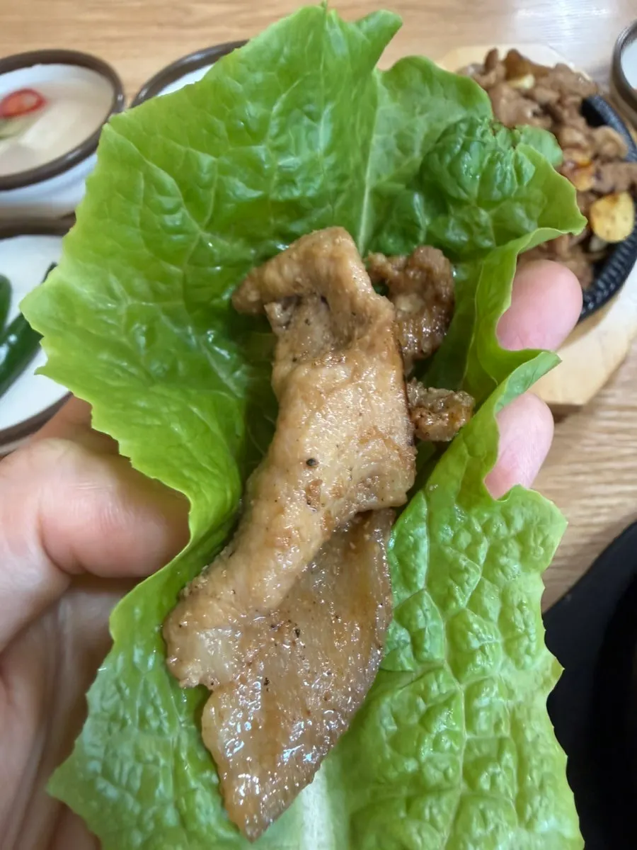 흑돼지불고기를 쌈채소에 싸는 모습