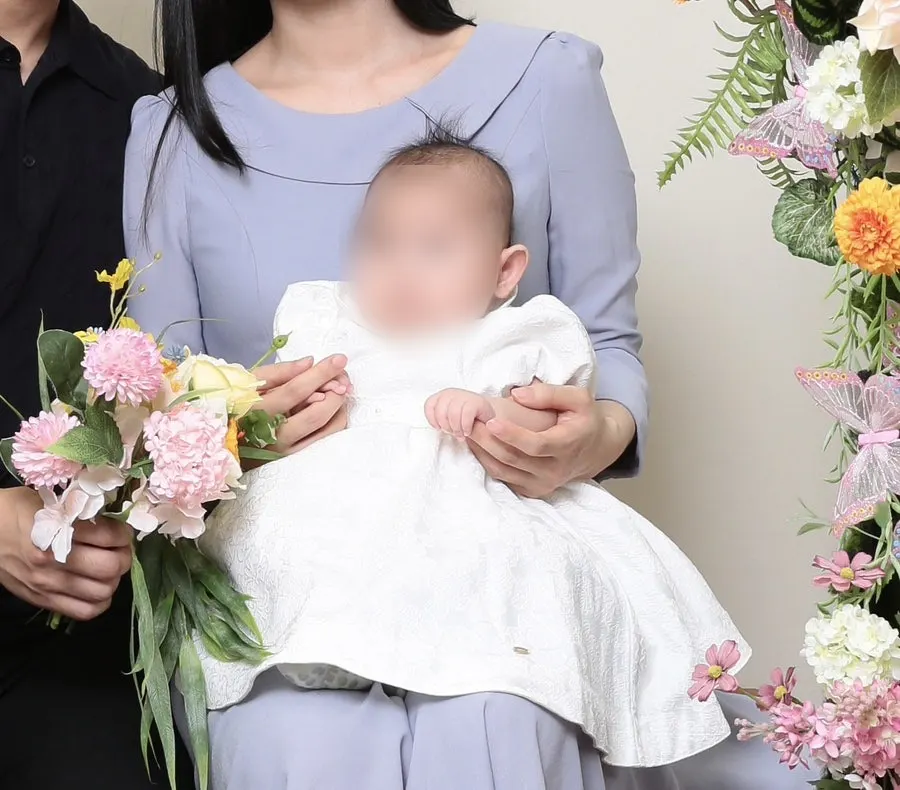 Milestone photo against a refined flower-decorated backdrop