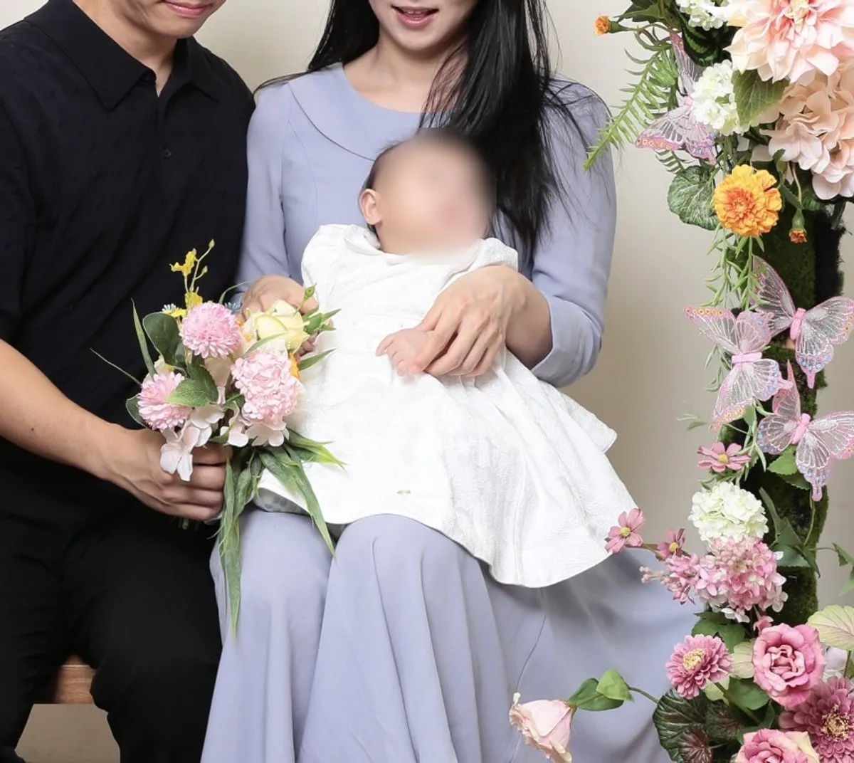Family photo scene for the 100-day celebration in front of the flower backdrop