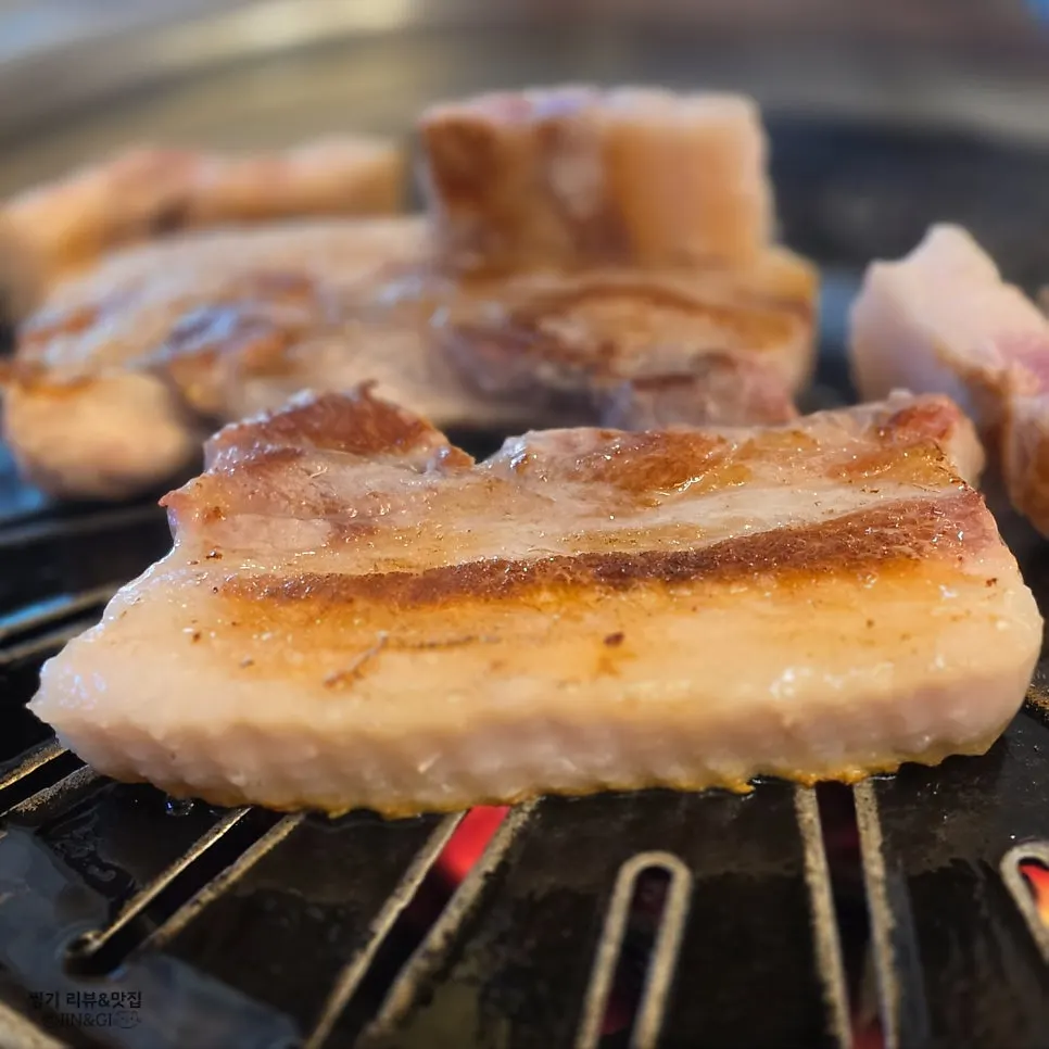 Thick pork belly grilled by a staff member