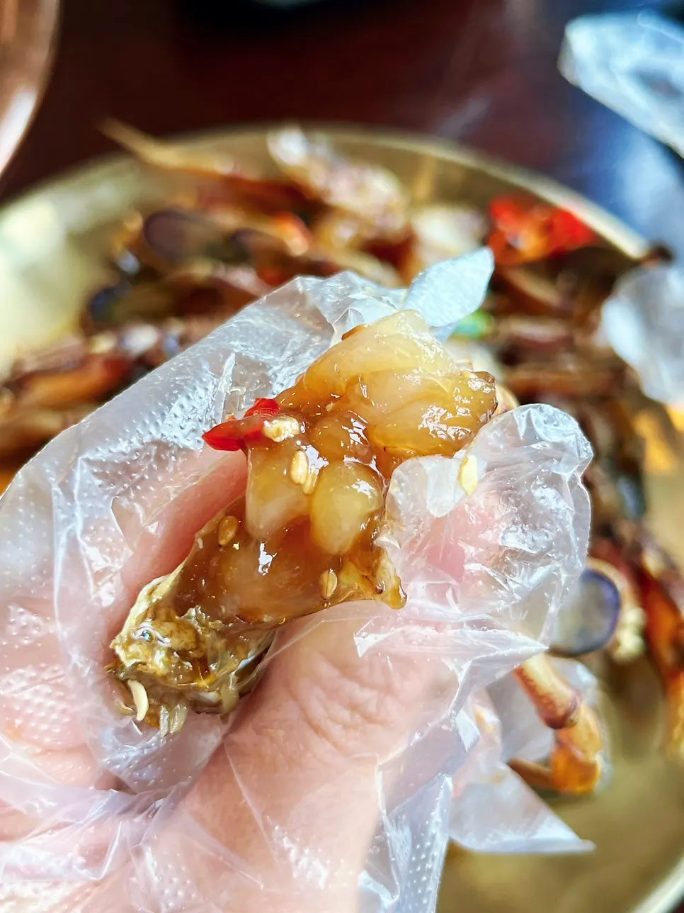 Eating soy crab with plastic gloves on
