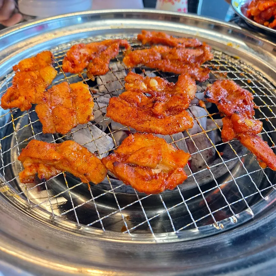 Red seasoned pork belly on the charcoal grill