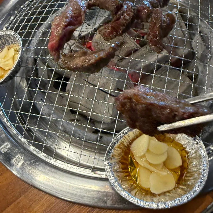 Beef ribs grilling over charcoal