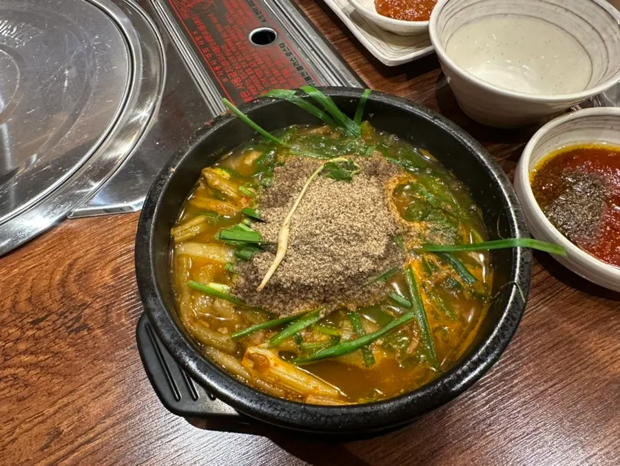 부추와 들깨가루 올린 염소탕 뚝배기