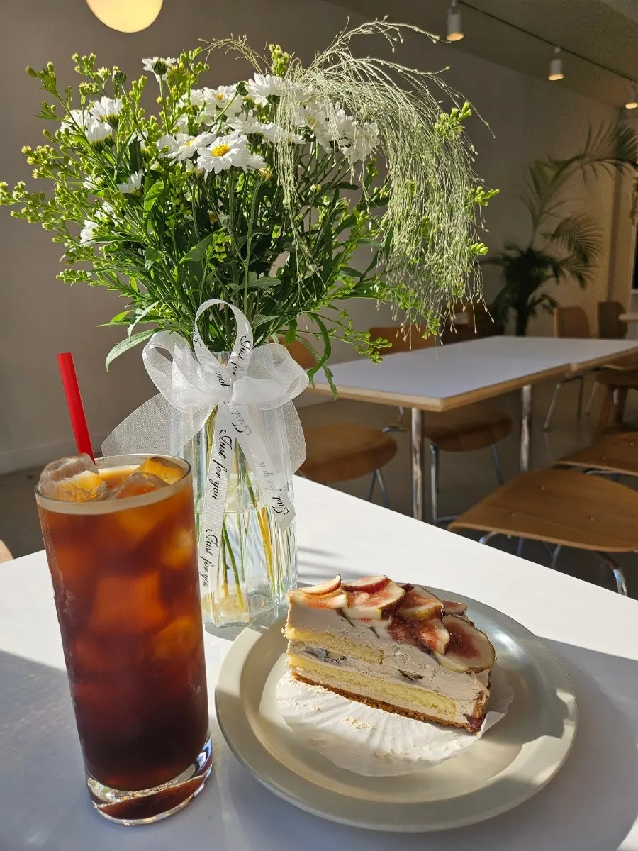A slice of fig cake photographed with flowers