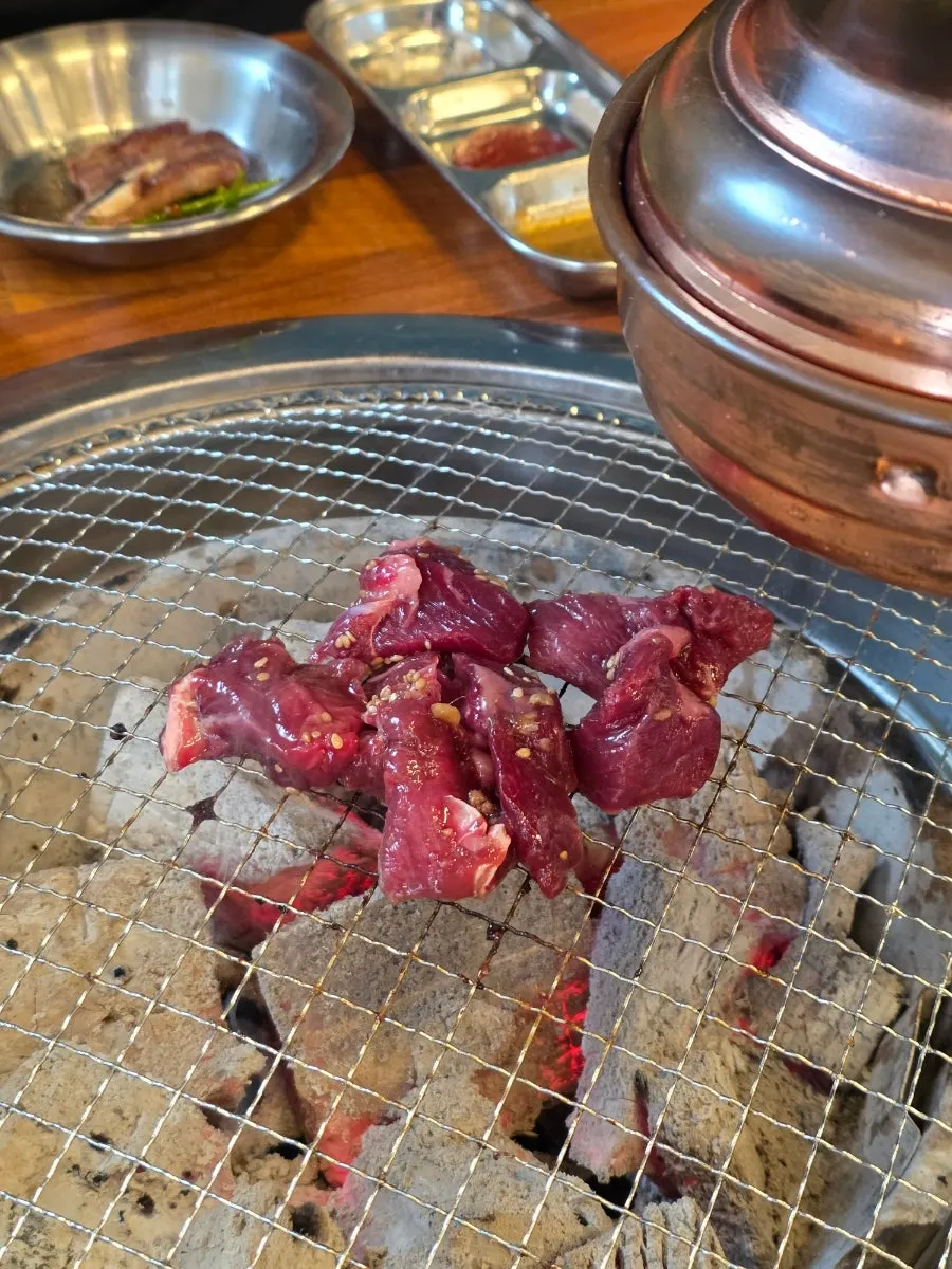 Woodae galbi grilling over charcoal