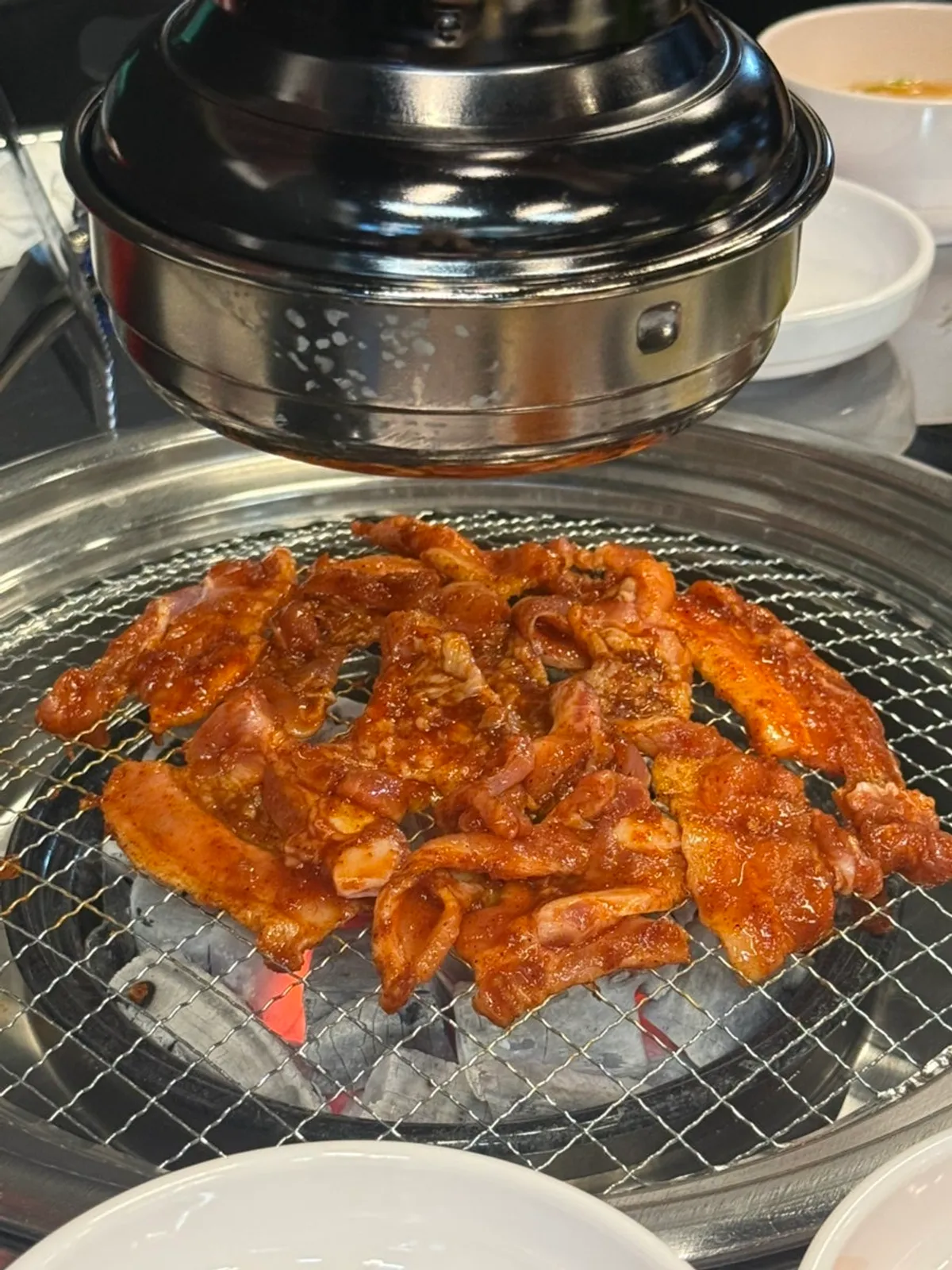 A plate of raw pork belly coated in red marinade
