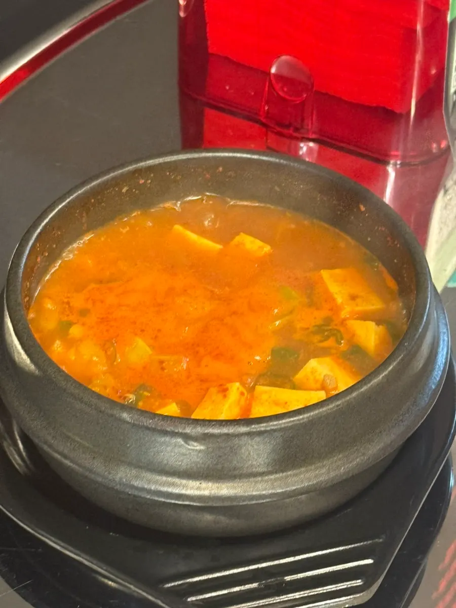 Bubbling hot kimchi jjigae in a stone pot