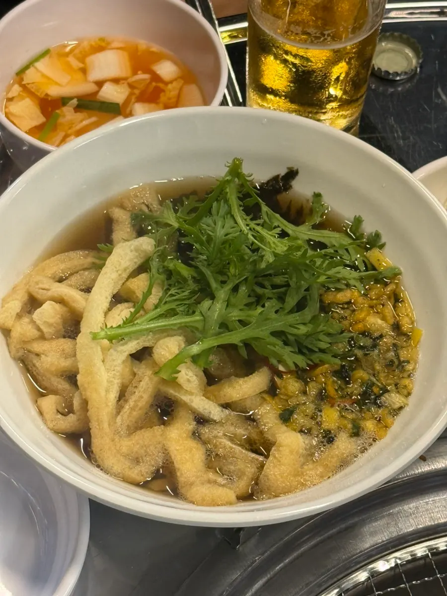 Udon topped with ssukgat greens and fried tofu